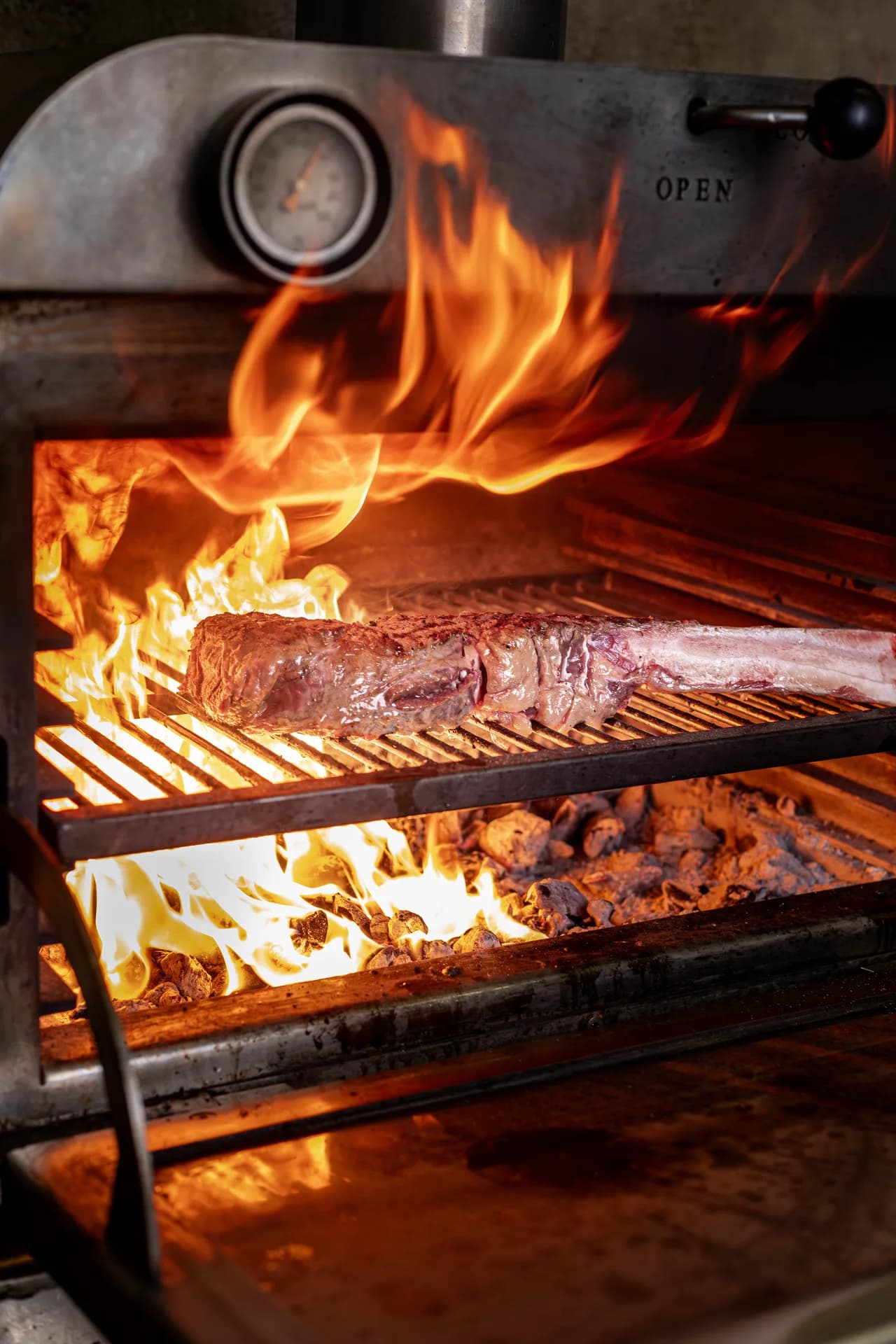 Steak cooking over an open flame at Lavigne.