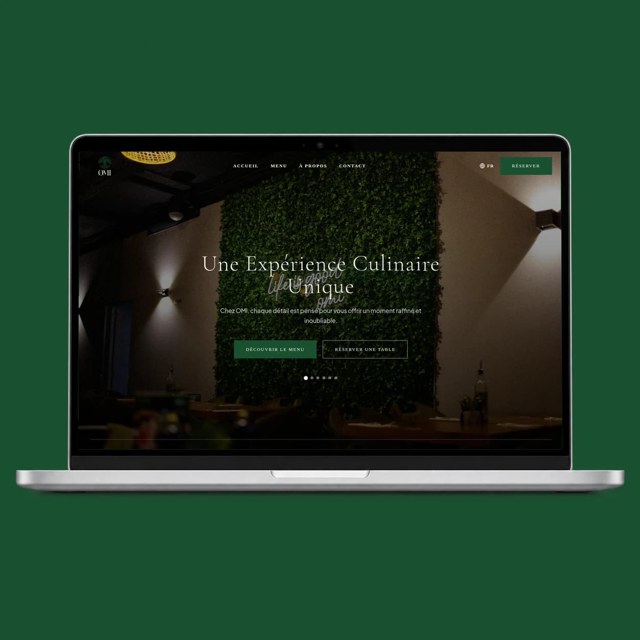 OMI restaurant website screenshot in a laptop on a green background.