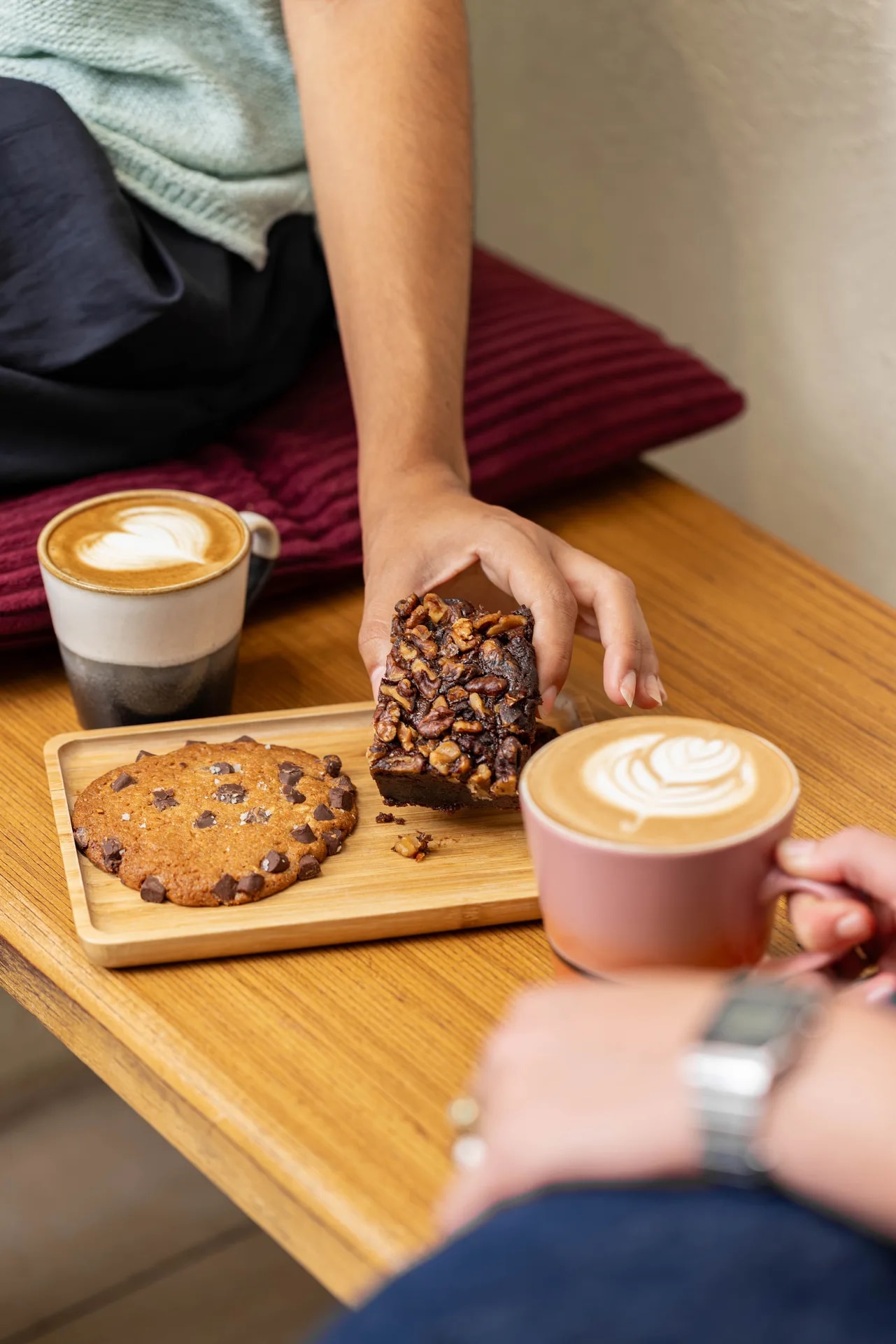 Two coffees, a cookie, and a brownie on a café table at Café Colombia.